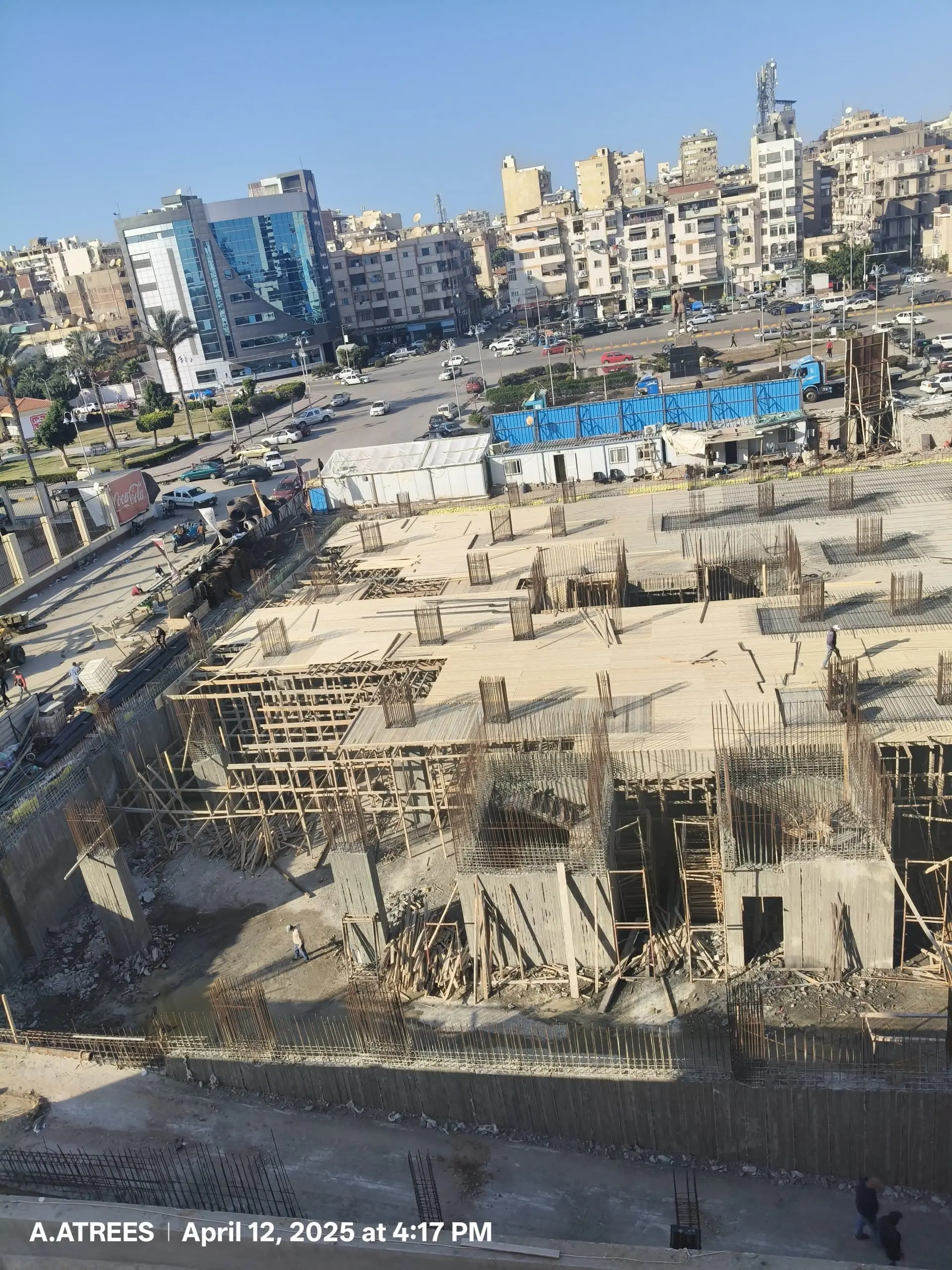 Construction site with completed slab and exposed rebar columns at DiamoNest Tower – موقع إنشاء برج ديامونيست مع بلاطة مكتملة وأعمدة حديد تسليح مكشوفة.