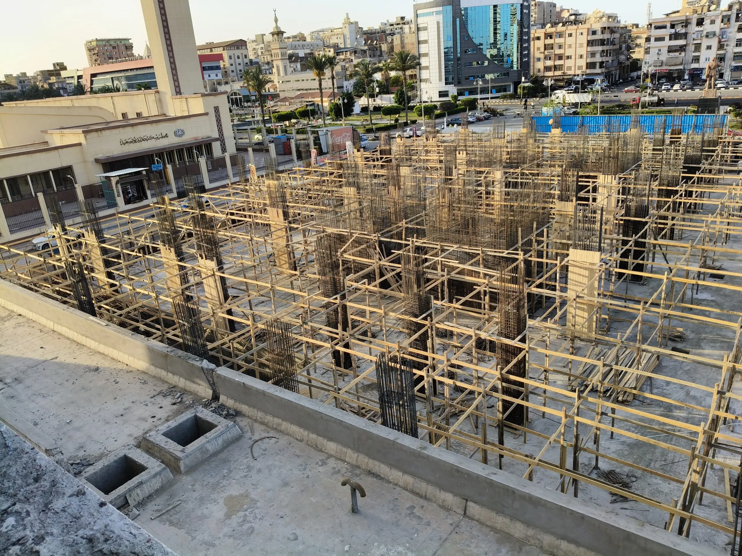 Early-stage concrete framework with rebar columns at DiamoNest Tower megaproject site – المرحلة المبكرة من قوالب الخرسانة وحديد الأعمدة في موقع مشروع برج ديامونيست العملاق.
